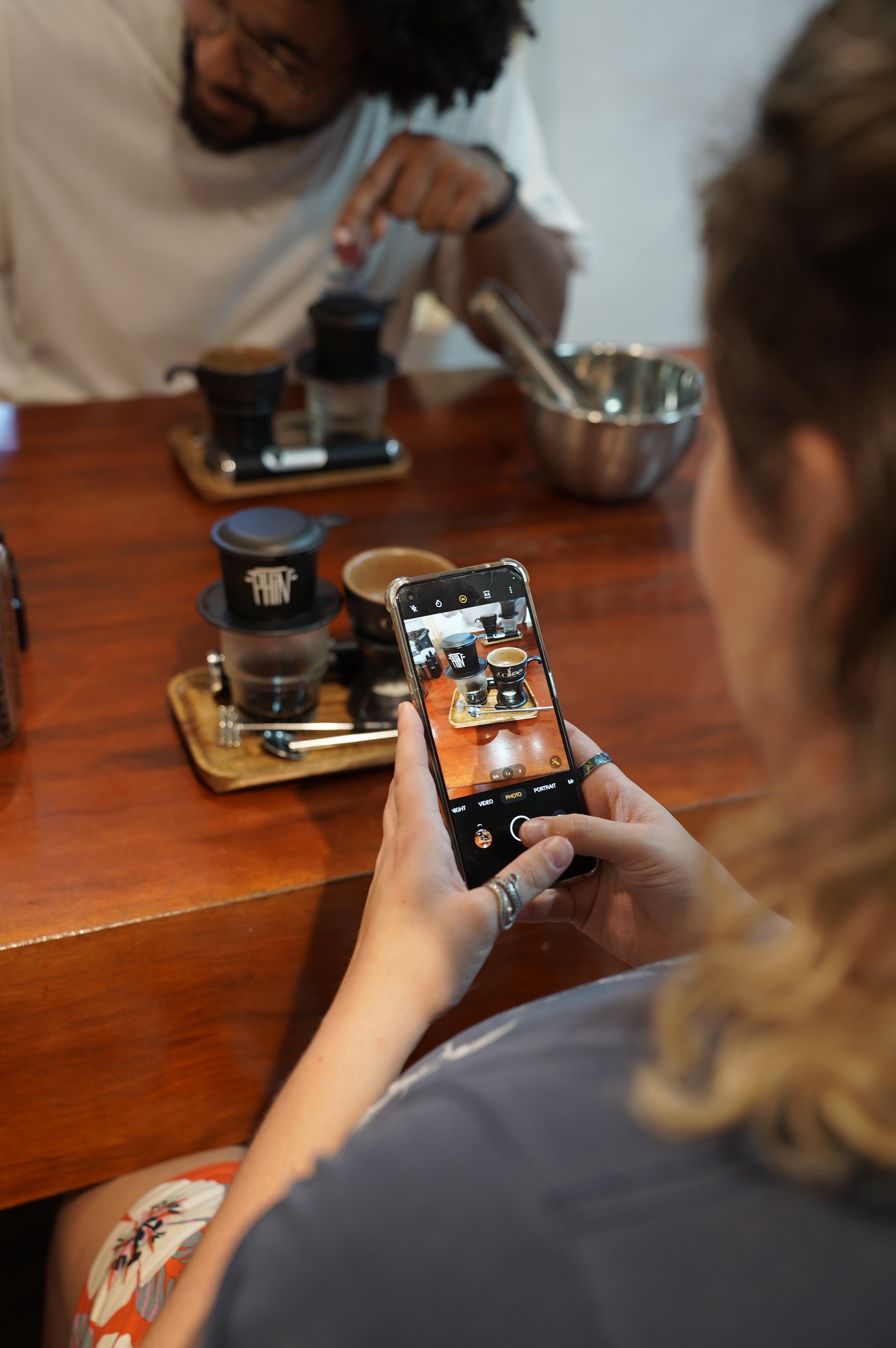 A guest photographing Vietnamese phin coffee.