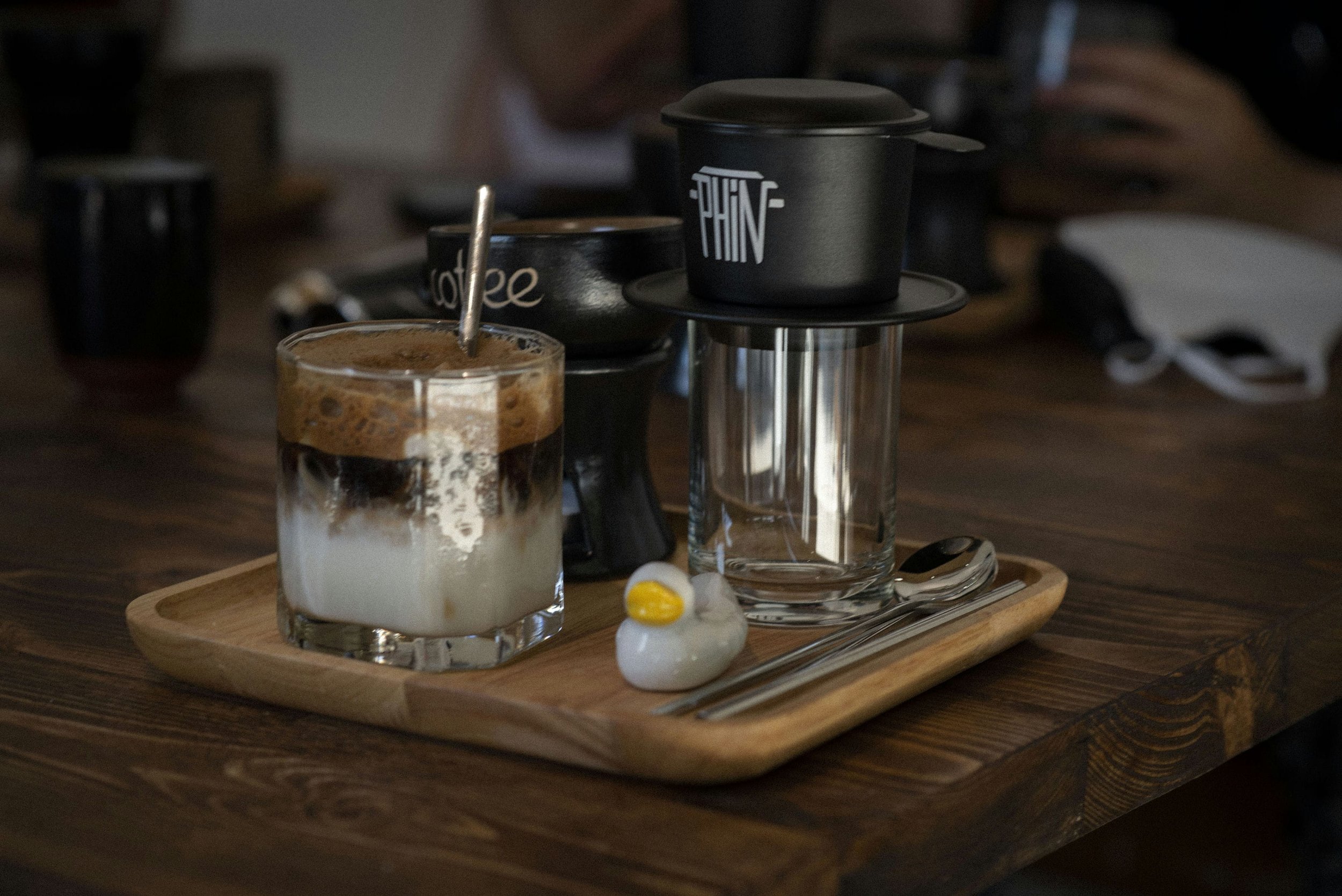 Vietnamese coffee served beside a phin filter.