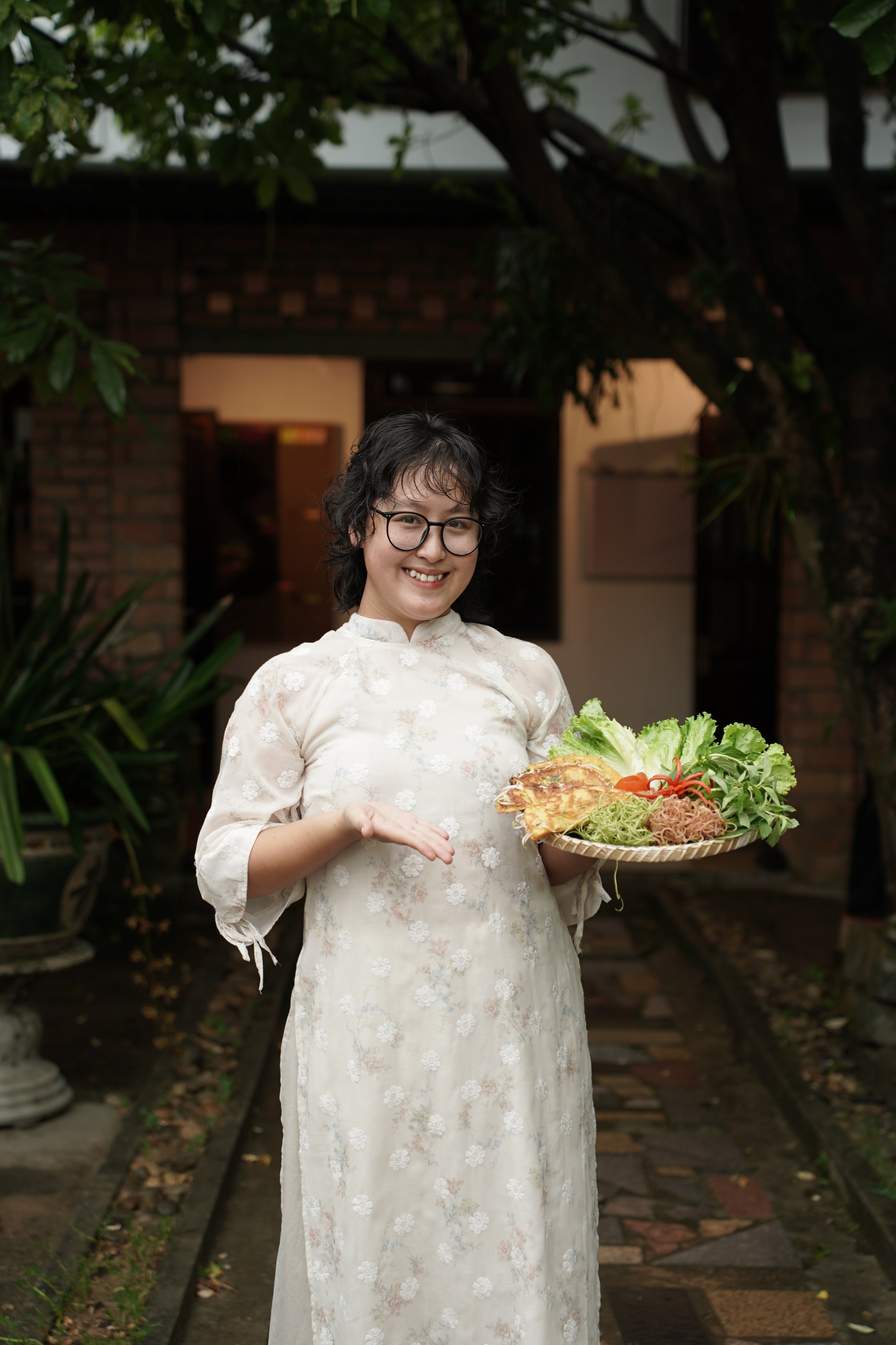 A Hue Experience instructor presenting a tray of dishes.