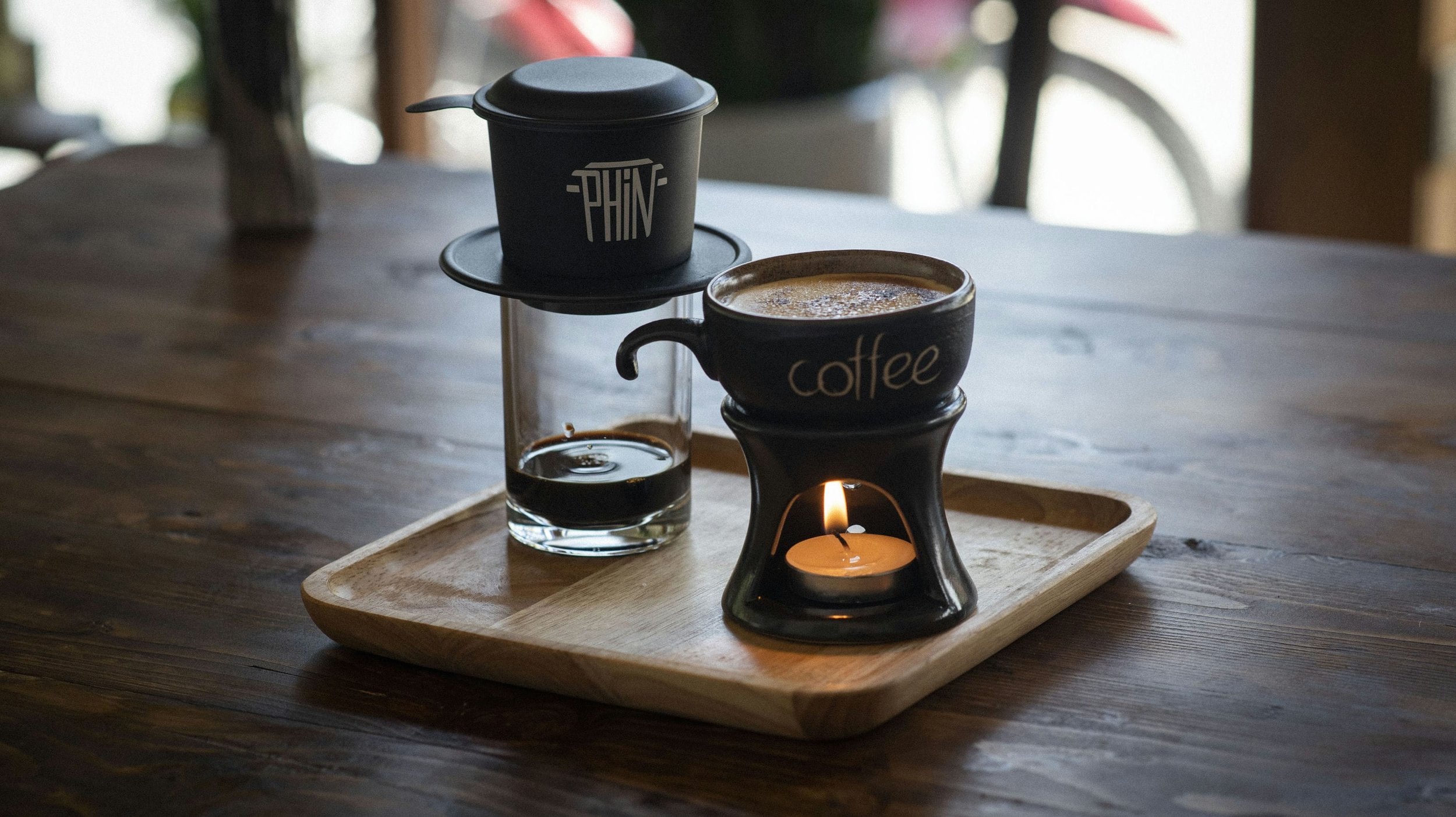 A Vietnamese phin filter and coffee served on a wooden tray